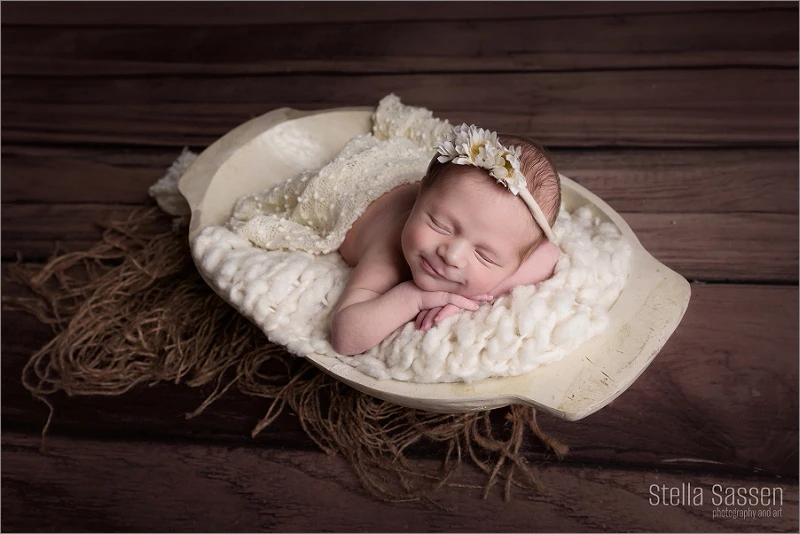 Smiling newborn baby in prop 